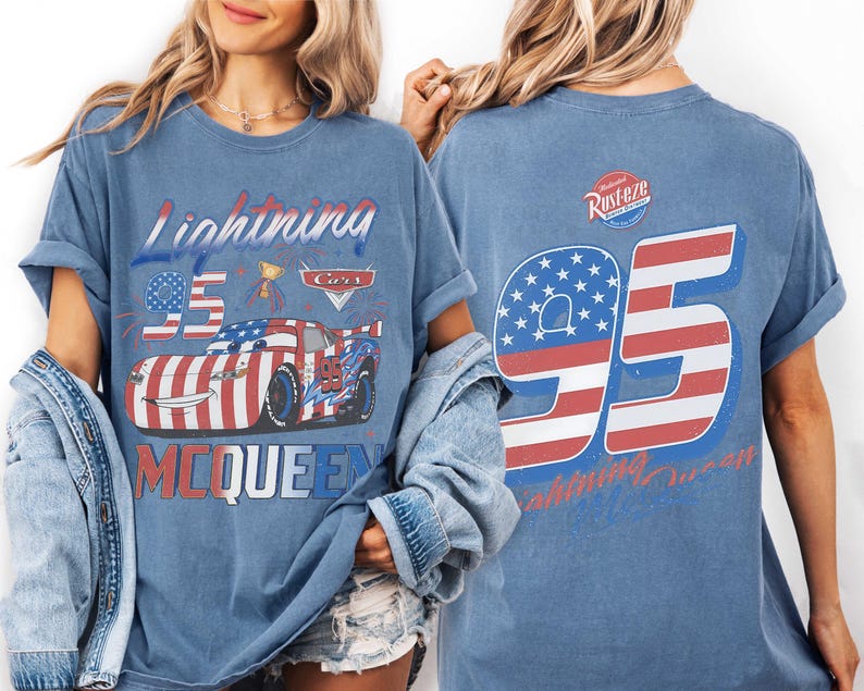 Może przedstawiać: Niebieski t-shirt z grafiką samochodu wyścigowego w barwach flagi amerykańskiej, numerem 95 i napisem Lightning McQueen z przodu. Z tyłu znajduje się duży numer 95 w paski flagi amerykańskiej oraz logo Rust-eze w g&oacute;rnej części koszulki.