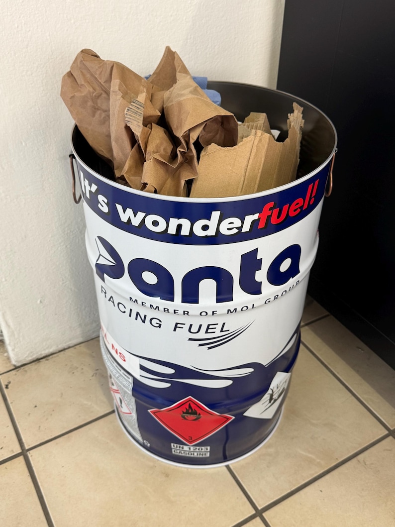 May include: A white and blue Panta Racing Fuel drum filled with brown paper and cardboard. The drum has a red hazard symbol and the text "It's wonderfuel!" and "Racing Fuel".