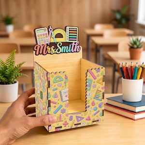 May include: A wooden desk organizer featuring a yellow pattern of school supplies like calculators, protractors, and abacuses. The top cutout displays the text Mrs. Smith in a colorful font, with 3D-style icons of a calculator, compass, and abacus.