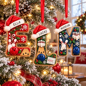May include: Three personalized Christmas ornaments shaped as letters E, L, and M. Each letter features a red Santa hat, bowling pins, a bowling ball, and holly berries. The letters are inscribed with the names Ella, Lucas, and Madelyn.