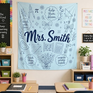 May include: A light blue wall tapestry featuring dark blue line art of school supplies, maths symbols, flowers, and bows. The text "Mrs. Smith" is centred in large script, surrounded by phrases like "help them bloom" and "teach with love."