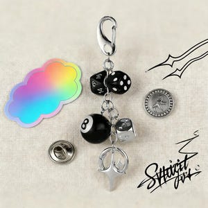 Może przedstawiać: Zestaw trzech ceramicznych kubków z nakrapianym, matowym wykończeniem. Kubki są w odcieniach kremu, jasnoszarym i ciemnoszarym. Każdy kubek ma prosty, minimalistyczny design i zaokrąglony uchwyt.