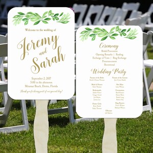 May include: A white wedding fan with green watercolor leaves and gold text. The fan says "Welcome to the wedding of Jeremy and Sarah" and includes the date, time, and location of the wedding. The back of the fan lists the wedding ceremony and reception details, including the names of the wedding party.