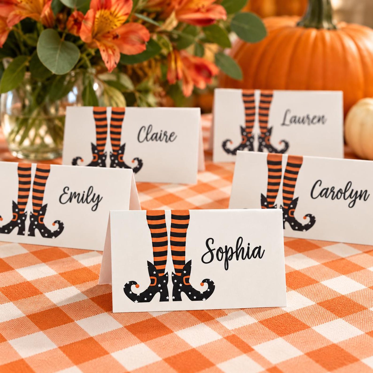 Striped Witch Legs Beside the Name White Halloween place cards with orange-and-black striped witch legs and black shoes.
