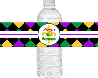 May include: Clear plastic water bottle with a white cap. The bottle has a decorative label with a purple, green, black, and yellow diamond pattern. The label also features the text "Avery's 16th Birthday" in a circle with a fleur-de-lis.