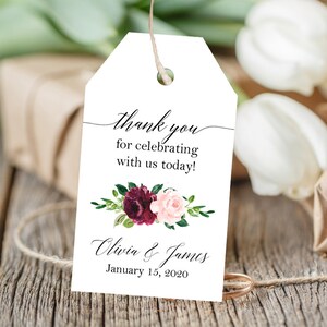 May include: White wedding favor tag with a burgundy and pink floral design. The text reads "thank you for celebrating with us today! Olivia & James January 15, 2020".
