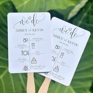 May include: Two white wedding fans with black text and icons. The fans feature the text "We Do" with the couple's names, "Abbey and Kevin", and the date "08.24.24". The fans also include a schedule of events for the wedding day, including the ceremony, cocktail hour, dinner, cake cutting, and dancing.
