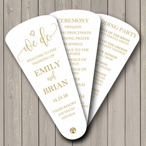 May include: White wedding ceremony program fan with gold text. The front side says "We Do" and includes the names Emily and Brian, the date 11.15.18, and the location Palms Resort, Las Vegas, Nevada. The back side lists the wedding ceremony order and the wedding party.