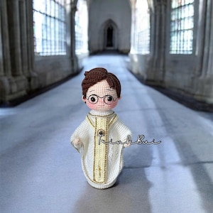 May include: A white ceramic mug with a black handle and the text "But First, Coffee" in a bold, black font. The mug is set against a blurred background, suggesting a cozy setting.