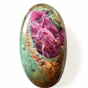 Può includere: Pietra preziosa di forma ovale con un vivace centro rosa e uno strato esterno verde e marrone. La pietra lucidata ha una superficie liscia e lucida, che mette in risalto i motivi e i colori naturali del minerale. La gemma è su sfondo bianco.