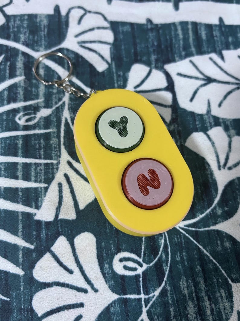 Bluey Toy - Front view. Green/Red buttons with a yellow body and a keychain.