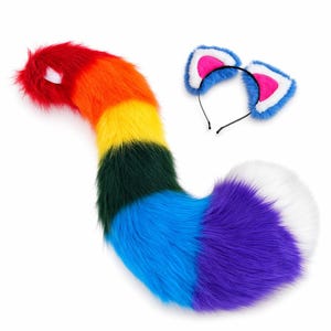 May include: A long, plush, faux fur tail featuring horizontal stripes of red, orange, yellow, green, blue, and purple, ending in a white tip. Accompanying the tail is a thin black headband with two plush cat ears that have blue fur, white trim, and bright pink inner fabric.