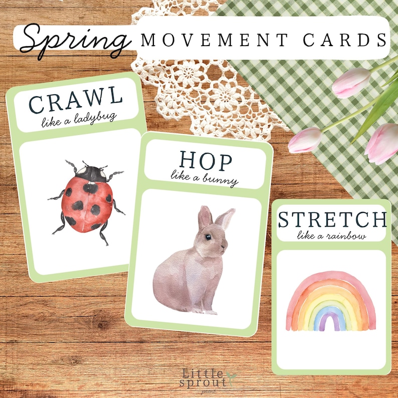 May include: Three spring-themed movement cards on a wooden surface. The cards feature illustrations of a ladybug, a bunny, and a rainbow, with instructions to crawl, hop, and stretch. The text "Spring Movement Cards" is at the top.