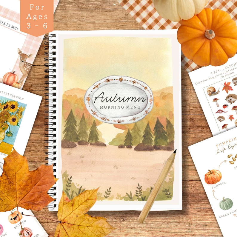 May include: A spiral-bound notebook with an autumn-themed watercolor illustration. The cover features the text "Autumn Morning Menu" within an oval frame. Additional cards with fall-themed illustrations and a pencil are also visible.