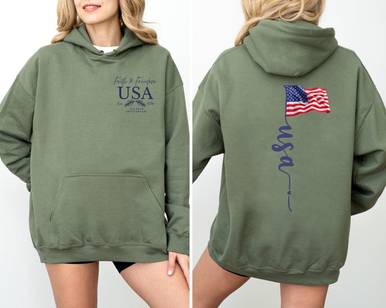 Puede incluir: Sudadera con capucha verde oliva con bolsillo delantero. La parte delantera presenta el texto "Faith & Freedom USA" con un emblema. La parte trasera muestra una bandera estadounidense ondeando y la palabra "usa" en cursiva.