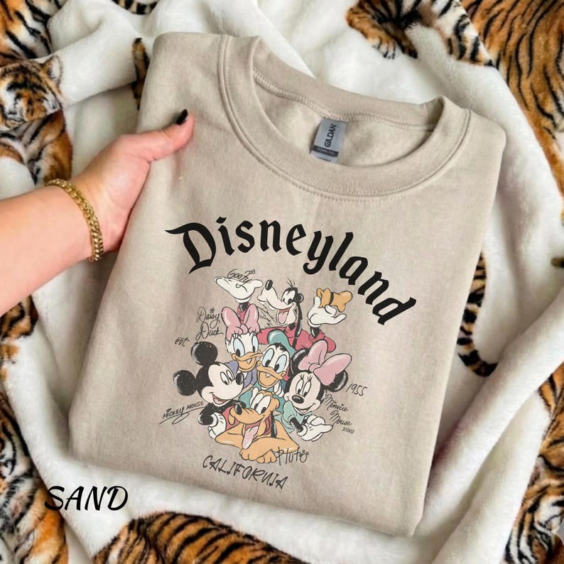 May include: A white ceramic mug with a black handle and the text "But First, Coffee" in a black, handwritten-style font. The mug is on a white surface.