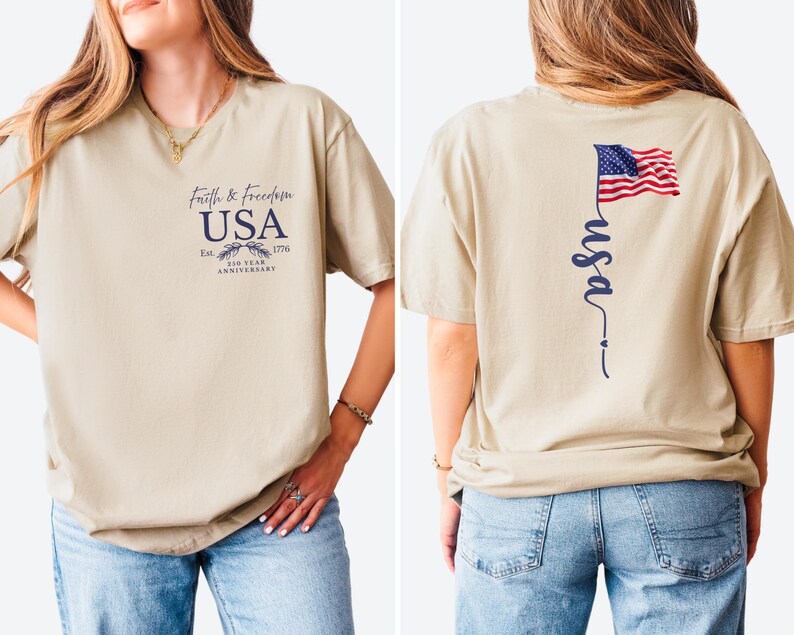 Puede incluir: Camiseta beige con texto "Faith & Freedom USA" y un gr&aacute;fico del 250 aniversario en la parte delantera. La parte trasera presenta una bandera americana ondeando y la palabra "usa" en cursiva.