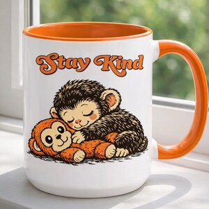 May include: A white ceramic mug with a black handle and the text "But First, Coffee" in a handwritten style. The mug is on a white surface. The mug is approximately 4 inches tall.