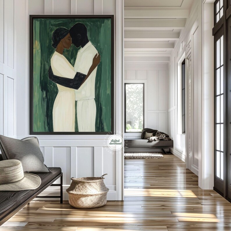 May include: A framed abstract painting depicts two figures embracing, set against a green backdrop. The figures are in white and black, with the woman in a cream-colored dress. The artwork hangs in a white-paneled hallway with a bench, hat, and woven basket.