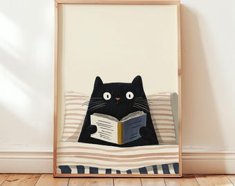 Puede incluir: Una impresión artística enmarcada que presenta un gato negro leyendo un libro en la cama. El gato tiene grandes ojos blancos y está rodeado por una almohada y una manta a rayas. El marco es de color marrón claro y el fondo es crema.