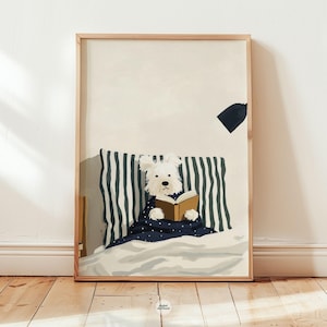 Puede incluir: Una impresión artística enmarcada que presenta un perro blanco leyendo un libro en la cama. El perro está cubierto con una manta azul marino con lunares blancos. La almohada tiene rayas verticales azul marino y blancas. La obra de arte está en un marco de madera.