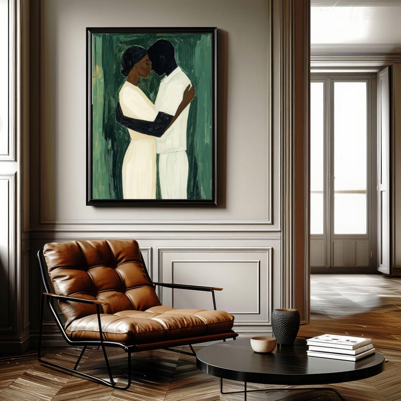 May include: A framed painting depicts two figures embracing, rendered in a minimalist style with black and white tones against a green backdrop. The artwork hangs above a brown leather armchair with a black metal frame, complemented by a round black coffee table.