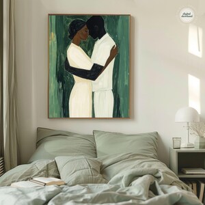May include: A framed painting depicts two figures embracing. One figure is in white, the other in black, set against a green backdrop. The artwork is displayed above a bed with green bedding.