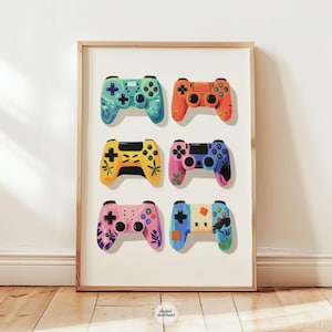 May include: A framed print featuring six colorful game controllers. Each controller has a unique design, with vibrant colors like blue, orange, yellow, pink, and green. The controllers are arranged in two rows of three, creating a visually appealing composition.