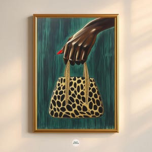 May include: A framed art print featuring a hand with a red painted fingernail holding a leopard print handbag. The background is a teal green color. The frame is gold.