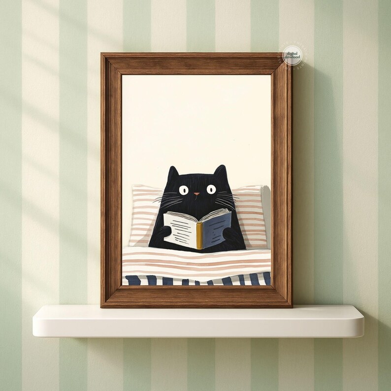 May include: A framed print featuring a black cat reading a book in bed. The cat is under a striped blanket and pillow. The frame is brown, and the background is a striped wall.