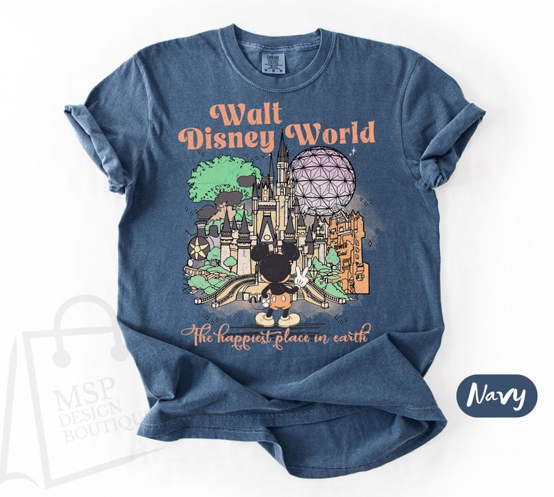 May include: Navy blue t-shirt featuring a colorful illustration of Walt Disney World with Mickey Mouse. The graphic includes the text "Walt Disney World" and "the happiest place in earth".