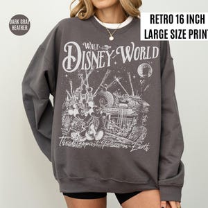 Peut inclure: Sweat-shirt gris fonc&eacute; chin&eacute; avec une impression r&eacute;tro de grande taille de 16 pouces. Le graphisme pr&eacute;sente les mots "Walt Disney World" et "The Happiest Place on Earth" avec une illustration d&eacute;taill&eacute;e de Mickey Mouse.