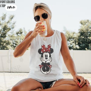 May include: A white tank top featuring a graphic print of a cartoon mouse with a red and white polka dot bow. The text COMFORT COLORS TANK TOP White is visible in the upper left corner, and the text MSP DESIGN BOUTIQUE is visible on the lower left.