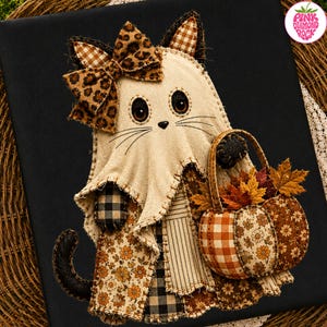 May include: A fabric wall hanging featuring a ghost-like cat figure with a leopard print bow, wearing a dress made of floral and plaid patches. The cat holds a small basket filled with fabric autumn leaves and two patterned fabric pumpkins.