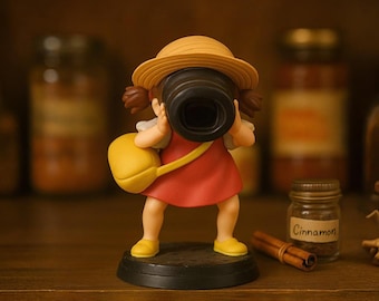 Adorable figurita inspirada en Mei Kusakabe mirando a través de un cubo. Pequeña pieza de colección hecha a mano, ideal para el escritorio o la habitación infantil.