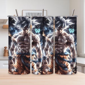 Puede incluir: Tres vasos de acero inoxidable con una ilustración detallada de un personaje de anime musculoso. El personaje tiene el pelo blanco, viste un atuendo naranja y azul, y está rodeado de rayos azules y efectos de fuego. Cada vaso tiene una pajita plateada.
