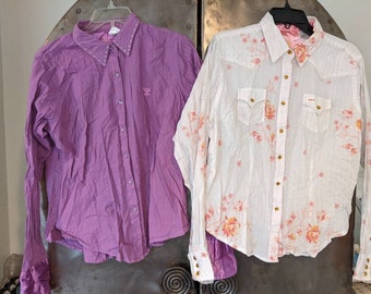 May include: Two long-sleeved shirts, one purple and one white with a floral pattern. Both shirts have a button-down front and a pointed collar.