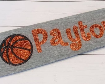 May include: Gray headband with the name "Payton" in orange glitter and a glitter orange basketball.