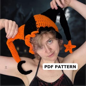 Könnte beinhalten: Ein handgefertigter Häkelhut in Schwarz und Orange, mit einer spitzen Spitze und einer sternförmigen Verzierung. Der Hut hat einen gerüschten Rand und einen geschwungenen, schwarzen Akzent. Der Text "PDF PATTERN" ist sichtbar.