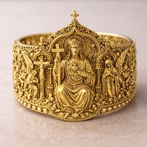 Pode incluir: Uma pulseira dourada com imagens religiosas detalhadas. O design apresenta uma figura central segurando uma cruz, ladeada por anjos e outras figuras religiosas. A pulseira tem um padrão ornamental em relevo.