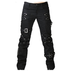 May include: Black pants with multiple straps, buckles, and metal rings. The pants have a classic five-pocket design with additional decorative elements. The style is reminiscent of alternative fashion.
