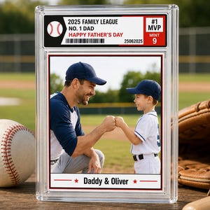 May include: A rectangular clear plastic slab containing a baseball-style trading card. The card features a photo of two people fist-bumping on a field. Text includes 2025 FAMILY LEAGUE, NO. 1 DAD, HAPPY FATHER'S DAY, #1 MVP, MINT 9, and Daddy & Oliver.