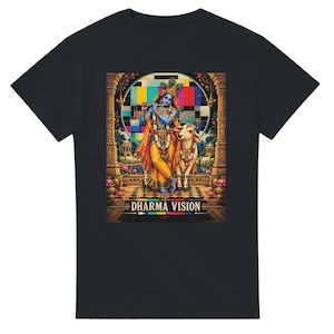 May include: A black t-shirt featuring a graphic print of a blue-skinned figure playing a flute next to a white cow. The design includes a colourful television test pattern background, architectural pillars, and the text DHARMA VISION at the bottom.