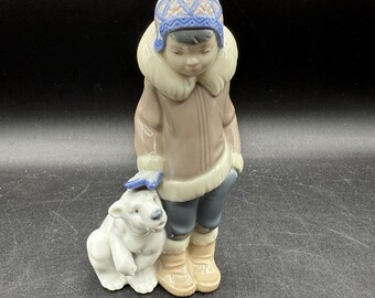Figura de niño esquimal y cachorro de oso polar pintada a mano de pie sobre una nieve Lladro 5238