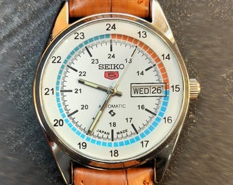 Reloj automático Seiko 5: piel auténtica, esfera blanca, fecha y día, fabricado en Japón.
