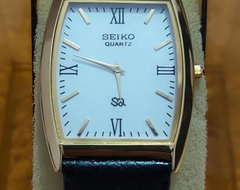 Reloj Seiko vintage de cuarzo chapado en oro, esfera blanca restaurada y correa de piel nueva.