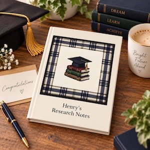 Puede incluir: Un cuaderno de tapa dura blanco con el texto Henry's Research Notes impreso en la portada. El centro presenta un gráfico cuadrado de un birrete de graduación sobre una pila de tres libros, enmarcado por un borde de cuadros azul marino y blanco.