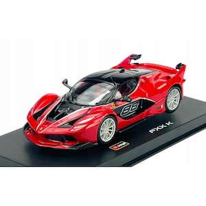 Könnte beinhalten: Ein rot-schwarzes Ferrari FXX K Modellauto mit der Nummer 88 auf der Seite. Das Modell hat silberne Räder und wird auf einer schwarzen Basis präsentiert. Der Text "FXX K" ist sichtbar.