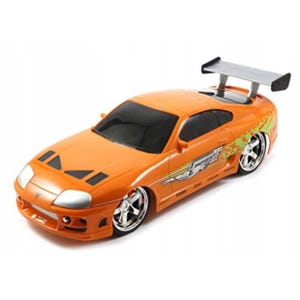 May include: Orange toy car with a rear spoiler and chrome wheels. The car has a detailed design with decals on the side. The car is a replica of a sports car.