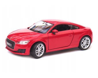 May include: A bright red Audi TT model car with silver wheels. The car has a sleek, aerodynamic design with the Audi logo on the front. The model car is a detailed replica of the original.